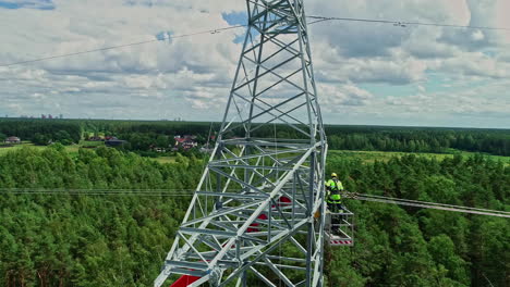 Flying-By-Steel-Pylon-Tower-With-Lineman-Working-On-An-Elevated-Platform