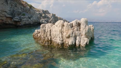 View-Of-Weathered-Rock-Located-Off-Kassiopi-Beach-In-Calm-Turquoise-Waters