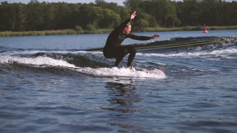 Surfer-Auf-Longboard-Surfen-Wellen-Hinter-Dem-Boot-Und-Machen-Tricks