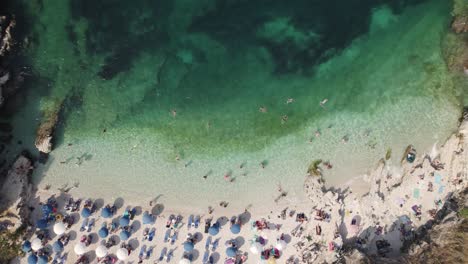 Aerial-Birds-Eye-View-Of-Busy-Kassiopi-Beach-With-Rows-Of-Parasols