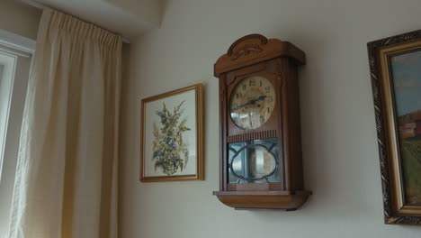 Old-antique-grandfathers-clock-hanging-and-ticking-on-an-egg-white-wall