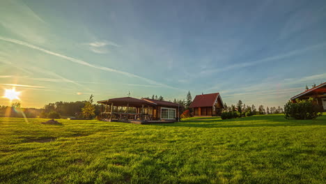 Timelapse-shot-of-tourist-wooden-cottages-surrounded-by-green-grasslands-during-evening-time