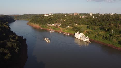 Tourist-boat-on-Iguazu-River-during-sunset-time---Border-between-Argentina-and-Brazil---Drone-shot
