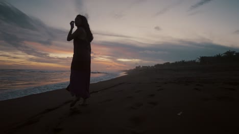 Traveler-Woman-Wearing-Dress-On-The-Beach-During-Sunset