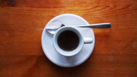 Down-shot-of-a-hot-espresso-cup-with-plate-and-spoon