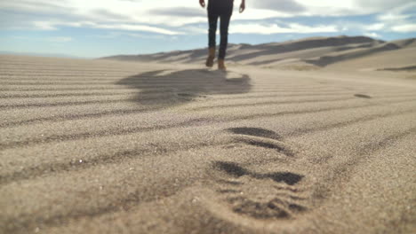 Explorer-Walking-Away-from-Camera-Leaving-Footprints-in-the-Sand-in-the-Desert