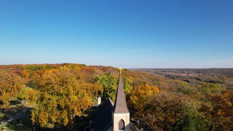 Small-Country-Catholic-Church-And-Old-Cemetry-In-Colorful-Rural-Autumn-Forest-Drone