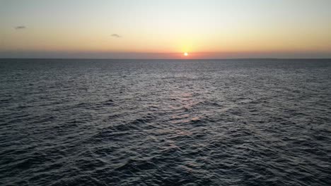 Indian-Ocean-sunset-horizon-at-Kusini-beach-East-Zanzibar-Island,-Tanzania-Africa,-Aerial-fast-flyover-shot