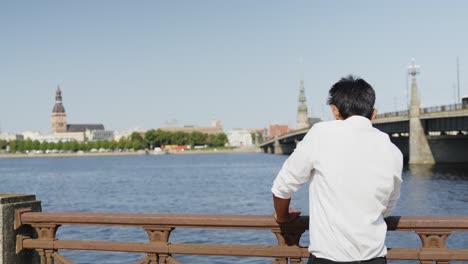 Indian-entrepreneur-enjoying-sunny-day-while-looking-towards-Riga-downtown