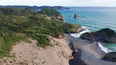 Aerial-Flying-Over-Beach-Towards-Green-Coastline-With-Waves-Gently-Crashing-On-Chiloe-Island,-Chile