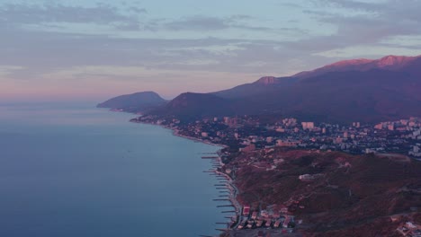 Morning-aerial-from-a-drone-over-the-black-sea-near-the-coast-with-a-view-of-the-mountains