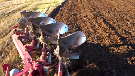 Heavy-equipment-plowing-soil-while-birds-land-behind,-POV-view