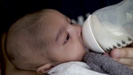 2-Monate-Alter-Indischer-Junge-Trinkt-Ruhig-Muttermilch-Aus-Der-Flasche-Und-Zappelt
