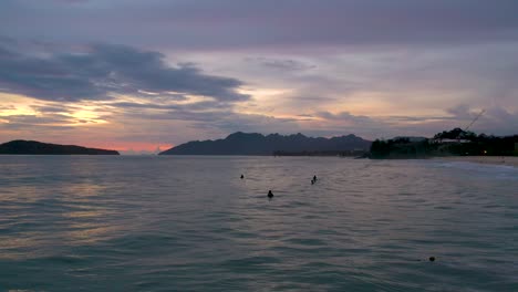 Surfers-watching-sunset-at-Pentai-Tengah-beach,-Langkawi-island,-Malaysia