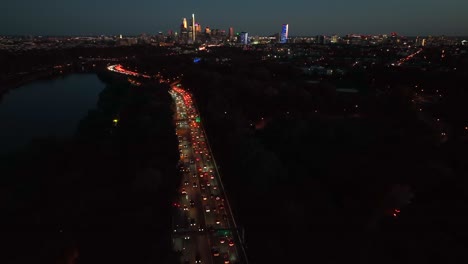 Traffic-jam-at-night-with-city-skyline-in-distance