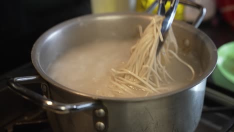 Chef-Tossing-Pasta-Noodles-In-A-Pot-Of-Boiling-Water-Using-Tongs