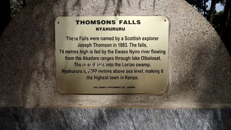 Thomson-Falls-informational-golden-sign-in-stone-at-Nyahururu,-Kenya,-Africa
