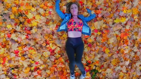 Aerial-young-women-laying-in-Fall-leafs-in-Slow-motion