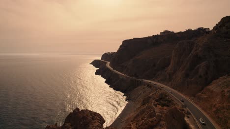 Aerial-Shot-Of-Long-Road-Built-Bottom-Of-High-Mountains,-Panoramic-Sea-View,-Almeria