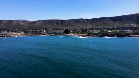 Panoramic-aerial-arc-of-kayaks-close-to-whales---Walker-Bay,-Hermanus