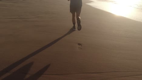 Slow-Motion-Follow-Shot-of-kids'-legs-Jogging-on-Beach-4K