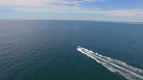 Powerboat-Moving-Fast-Through-Ocean-In-Sunny-Afternoon-Aerial-Forward-Tracking
