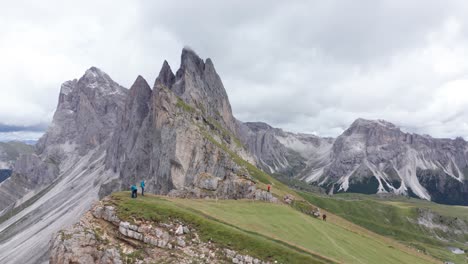 Menschen,-Die-Entlang-Der-Seceda-Wandern,-Mit-Fermeda-Türmen-Im-Hintergrund,-Dolomiten,-Antenne