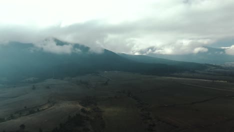 Drone-shot-of-a-field-and-мountain-with-cloudy-sky