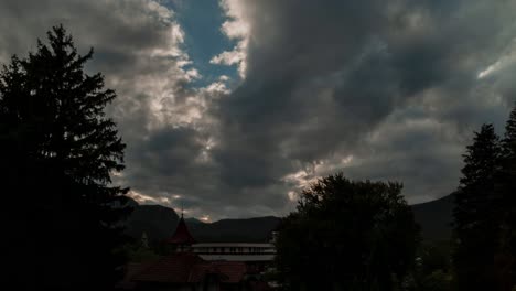 Timelapse-of-sun-rays-emerging-through-the-clouds-in-the-mountains-at-sunset-bavaria,-germany