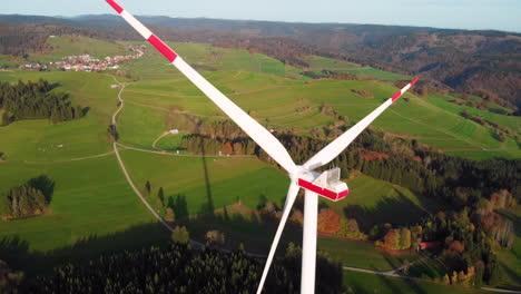 Turning-wind-turbine-over-looking-pictures-mountains-landscape-with-village-30fps-4k
