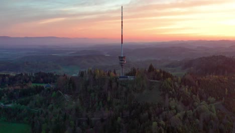 Aerial-drone-view-from-above-the-Bantiger-TV-tower-near-bern-on-a-gorgeous-morning-with-dramatic-sunrise-colors-and-lush-mountain-views