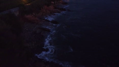 Drone-flying-over-beach-at-sunset