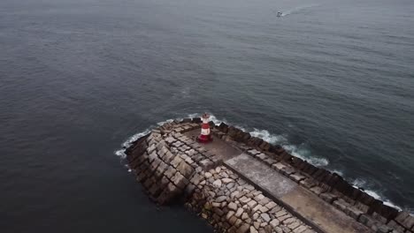 Drone-shot-over-the-lighthouse-with-boat-aproaching
