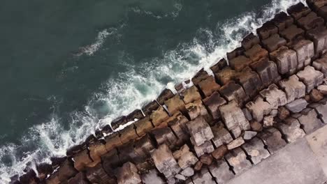 Drone-Shot-top-view-Waves-hitting-the-pier