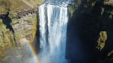 Epischer-Rückzugsschuss-Eines-Mächtigen-Wasserfalls-In-Island,-Wasser,-Das-Eine-Hohe-Klippe-Hinunterstürzt