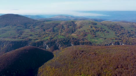 Luftdrohnenvideo-Der-Ländlichen-Landschaftslandschaft-Mit-Orangefarbenen-Herbstbäumen-Und-Grünen-Feldern