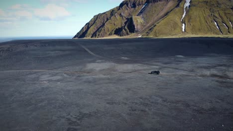Vehículo-Todoterreno-En-El-Desierto-Virgen-Frente-Al-Paisaje-De-Altas-Montañas,-Islandia