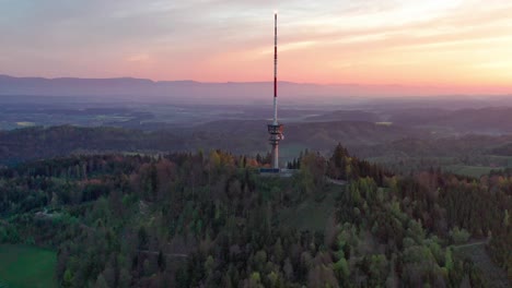 Aerial-drone-view-from-above-the-Bantiger-TV-tower-near-bern-on-a-gorgeous-morning-with-dramatic-sunrise-colors-and-lush-mountain-views