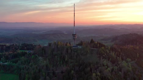 Aerial-drone-view-from-above-the-Bantiger-TV-tower-on-a-gorgeous-morning-with-dramatic-sunrise-colors-and-lush-mountain-views