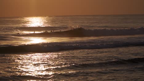 Surfer,-Der-Eine-Welle-In-Der-Silhouette-Gegen-Die-Untergehende-Sonne-Reitet---Slomo