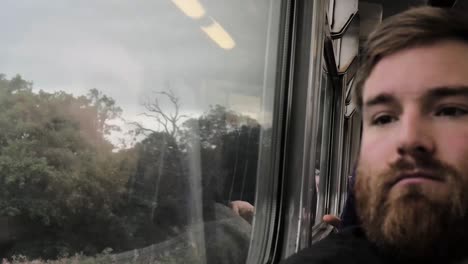Bearded-Man-Looks-Out-Of-The-Train-Window