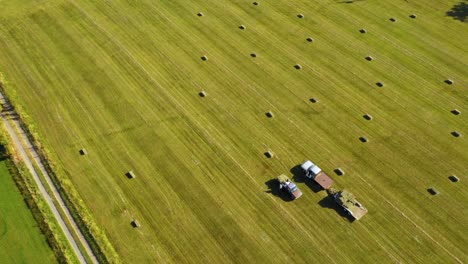 Aerial-view-of-people-harvest-square-bales-in-a-field