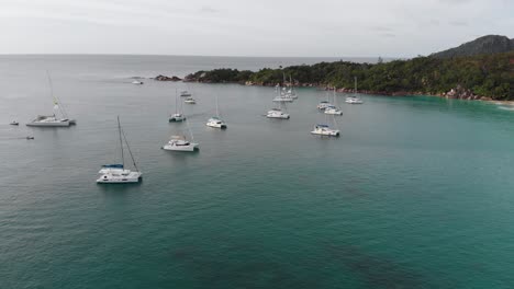 Aerial-view-of-boats-and-yachts-in-the-turquoise-waters-of-the-indian-ocean-around-La-Digue,-an-island-of-the-Seychelles