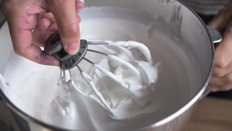 baker-scoops-white-icing-bowl-slow-mo
