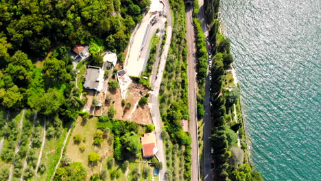 Downward-facing-drone-shot-of-road-alongside-Lake-Como-in-Varenna,-Italy
