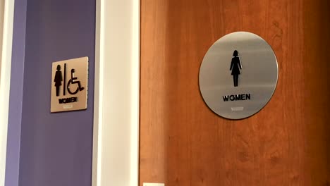 Women's-bathroom-sign-on-wooden-door-in-corporate-office-environment