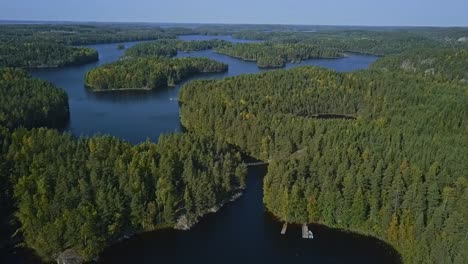 Aerial-view-on-a-floating-bridge-on-ropes-over-a-lake-or-a-stream-in-a-forest,-summer,-aerial-epic-wide-shot-with-islands,-lakes-and-forest