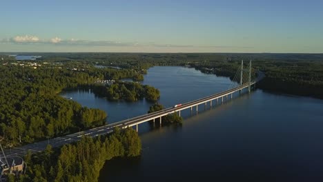 Long-bridge-over-a-lake-in-Heinola,-Finland,-revealing-Nordic-landscape,-houses,-cars