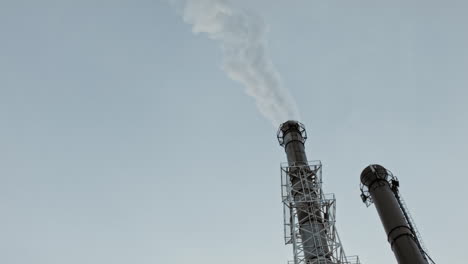 Industrielle-Fabrikpfeife-über-Einem-Blauen-Himmel-Mit-Viel-Rauch-Vom-Boden