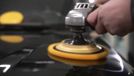 Car-polish-with-a-yellow-grinding-machine-close-up-in-50fps,-slow-motion-ready